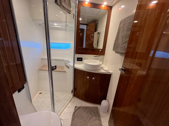 Mon Trésor Yacht Photos Pics Luxurious bathroom in 2020 Riviera 6000 Sport Yacht Platinum Edition with modern fixtures and wood accents.