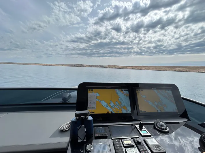  Yacht Photos Pics Cockpit view of 2024 Cranchi Sessantasette 67 yacht with navigation screens and ocean horizon.