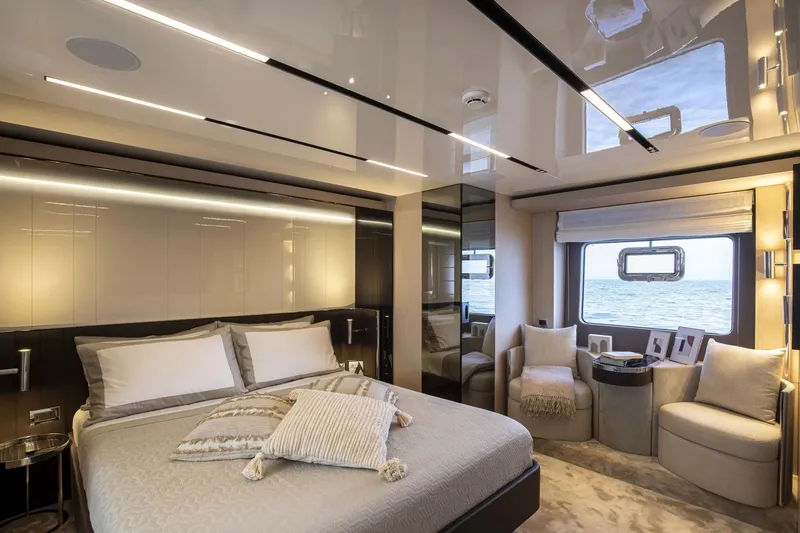  Yacht Photos Pics Luxurious bedroom interior of 2024 Cranchi Sessantasette 67 yacht with ocean view.