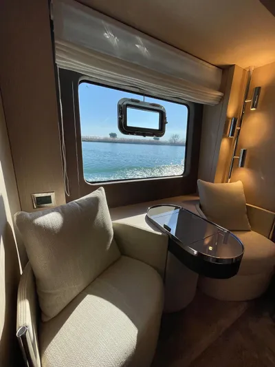  Yacht Photos Pics Luxurious interior of 2024 Cranchi Sessantasette 67 yacht with window view of water.