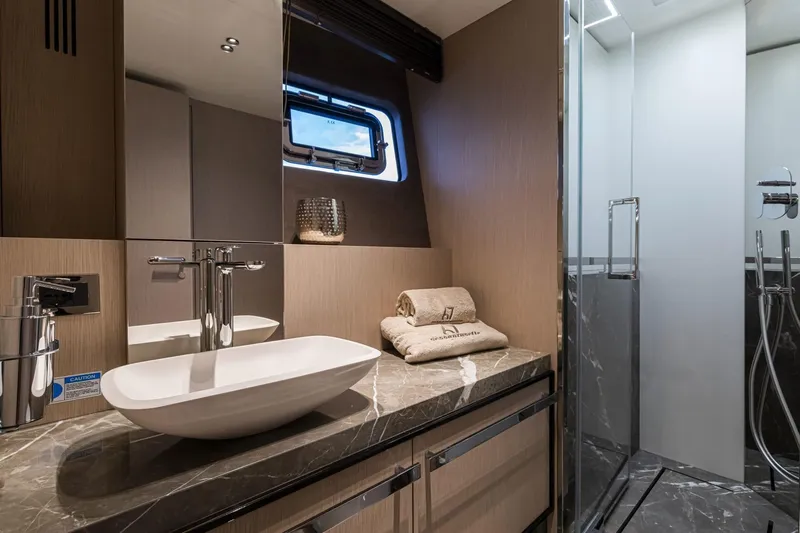  Yacht Photos Pics Luxurious bathroom in 2024 Cranchi Sessantasette 67 yacht with modern sink and shower.