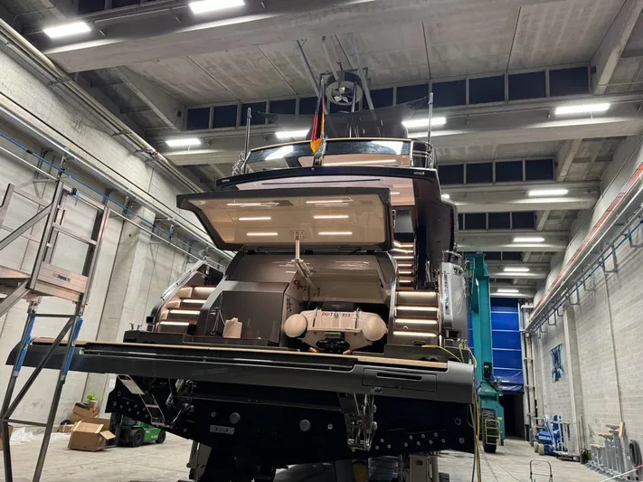  Yacht Photos Pics 2024 Cranchi Sessantasette 67 yacht in a shipyard, rear view with open compartments.