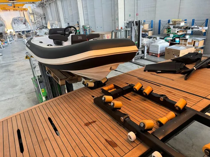  Yacht Photos Pics 2024 Cranchi Sessantasette 67 in a workshop, featuring a sleek design and wooden flooring.