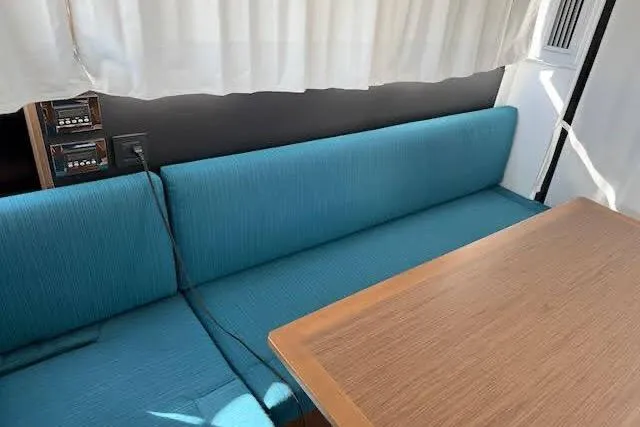 Sweet & Salty Yacht Photos Pics Interior of 2019 Jeanneau Velasco 37F with blue seating and wooden table.
