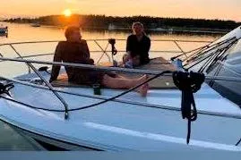 Sweet & Salty Yacht Photos Pics 2019 Jeanneau Velasco 37F yacht at sunset with people relaxing on deck.