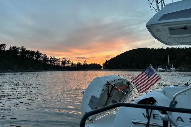 Sweet & Salty Yacht Photos Pics 2019 Jeanneau Velasco 37F at sunset on tranquil waters with American flag.