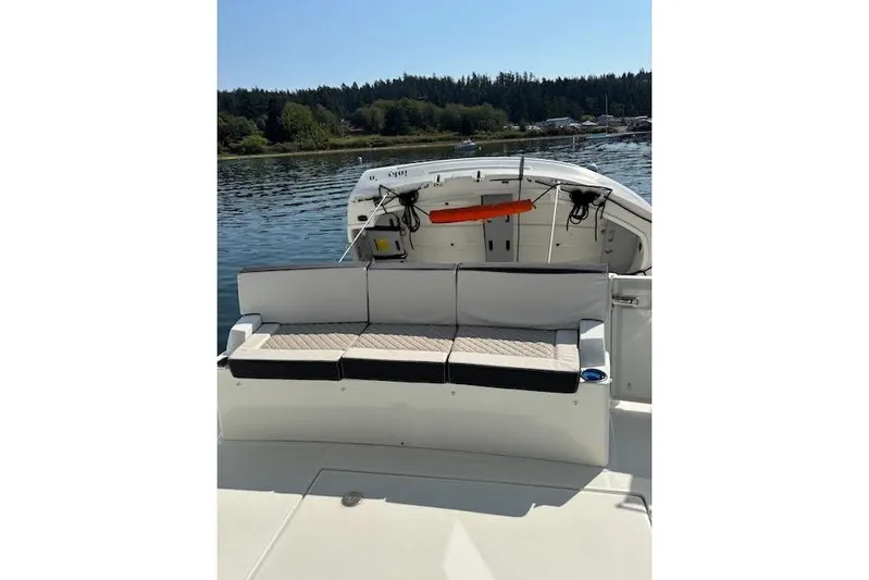 Sweet & Salty Yacht Photos Pics 2019 Jeanneau Velasco 37F boat with cushioned seating, docked on a serene lake.