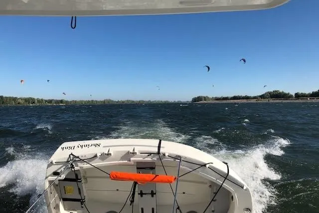 Sweet & Salty Yacht Photos Pics 2019 Jeanneau Velasco 37F cruising on a windy day with kite surfers in the distance.