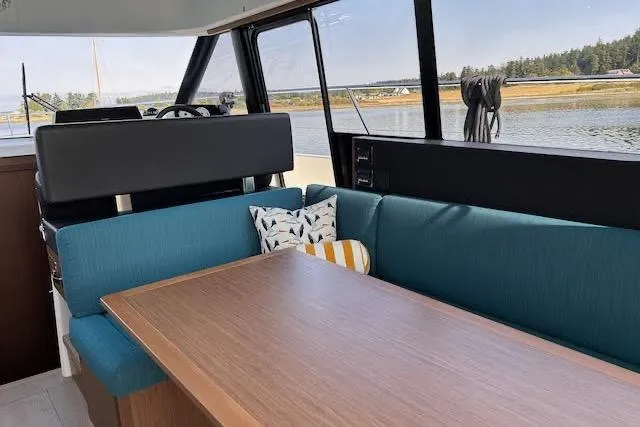 Sweet & Salty Yacht Photos Pics Interior of 2019 Jeanneau Velasco 37F yacht with blue seating and wooden table.
