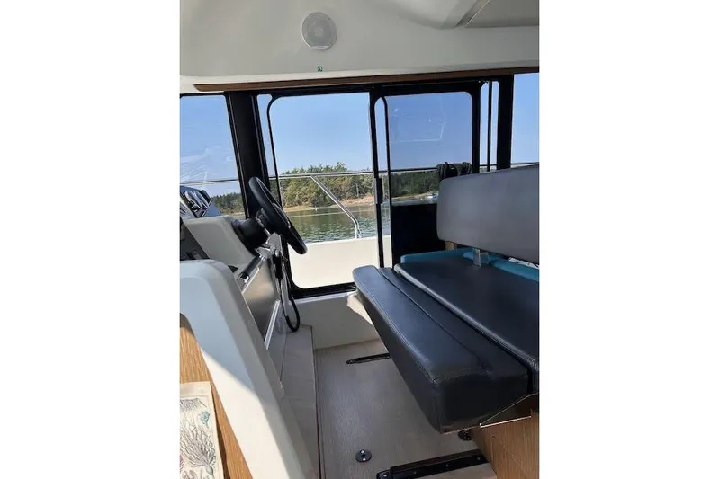 Sweet & Salty Yacht Photos Pics Interior view of 2019 Jeanneau Velasco 37F boat with steering wheel and seating.