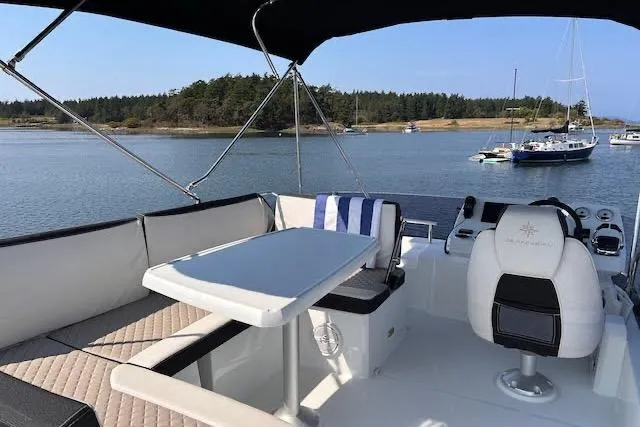 Sweet & Salty Yacht Photos Pics 2019 Jeanneau Velasco 37F yacht interior with seating and table, overlooking serene waters.