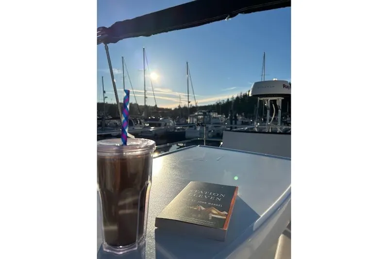 Sweet & Salty Yacht Photos Pics Jeanneau Velasco 37F yacht deck with iced coffee and book at sunset.
