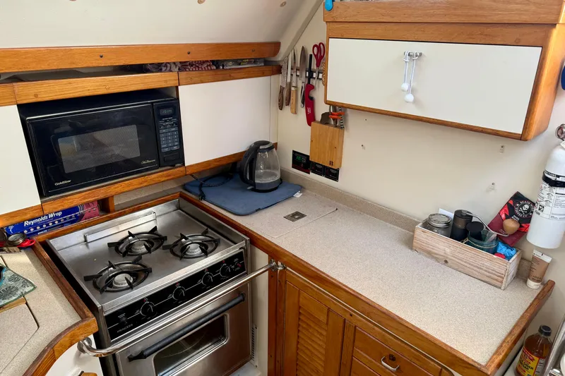  Yacht Photos Pics Compact kitchen in a 1996 Catalina 400 sailboat with stove, microwave, and kettle.