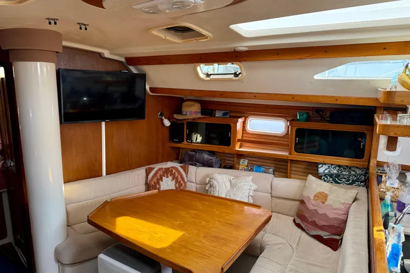  Yacht Photos Pics Cozy interior of a 1996 Catalina 400 sailboat with a comfortable seating area and wooden table.