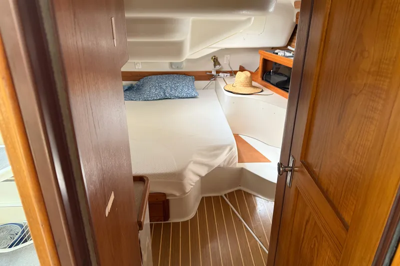  Yacht Photos Pics Cozy cabin interior of 1996 Catalina 400 sailboat with wooden accents and bed.