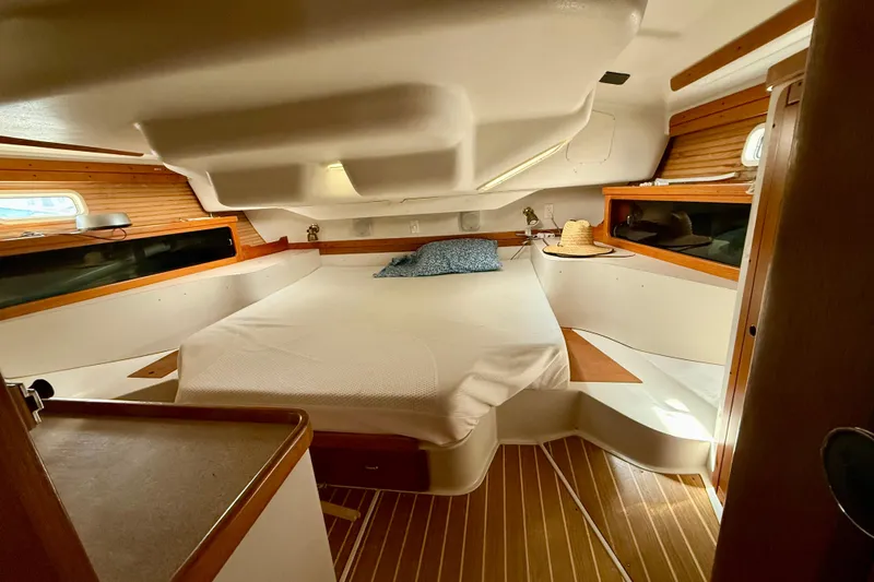  Yacht Photos Pics Cozy cabin interior of a 1996 Catalina 400 sailboat with wooden accents and a comfortable bed.