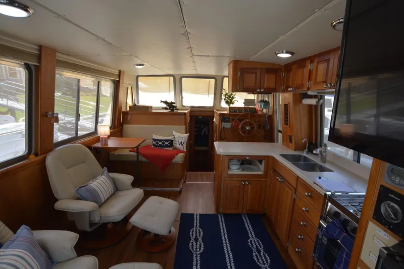 Standing By Yacht Photos Pics Interior of 2004 Mainship 400 Trawler with cozy seating and modern kitchen amenities.