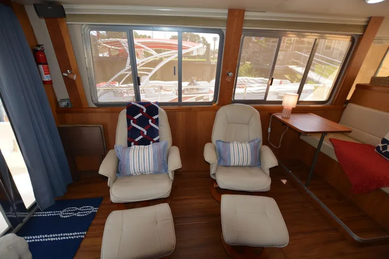 Standing By Yacht Photos Pics Interior of 2004 Mainship 400 Trawler with comfortable seating and nautical decor.