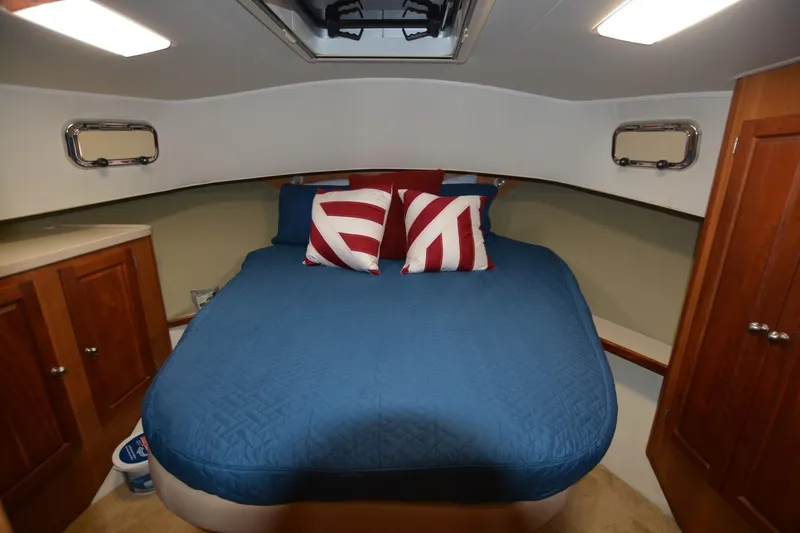 Standing By Yacht Photos Pics Cozy cabin interior of 2004 Mainship 400 Trawler with blue bedding and nautical decor.