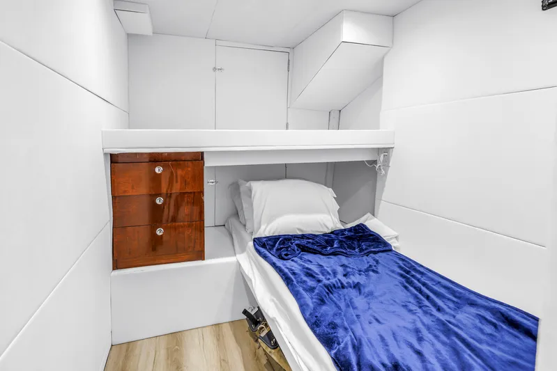 Star Saphire Yacht Photos Pics Small cabin interior with single bed, blue blanket, and wooden drawers on a 2007 Bilgin 117 yacht.