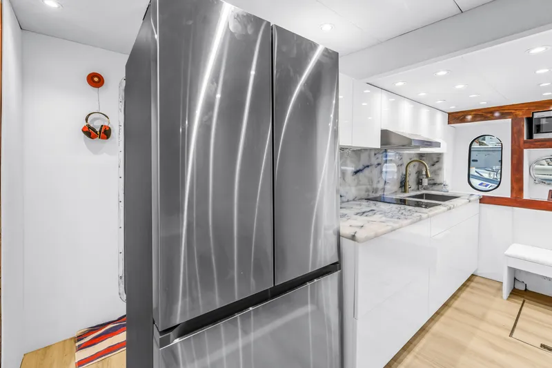 Star Saphire Yacht Photos Pics Modern yacht kitchen interior with stainless steel appliances, marble countertops, and sleek white cabinetry.