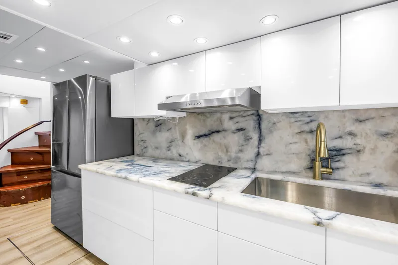 Star Saphire Yacht Photos Pics Modern yacht kitchen with marble countertops, stainless steel appliances, and sleek white cabinetry. Bilgin 117, 2007.