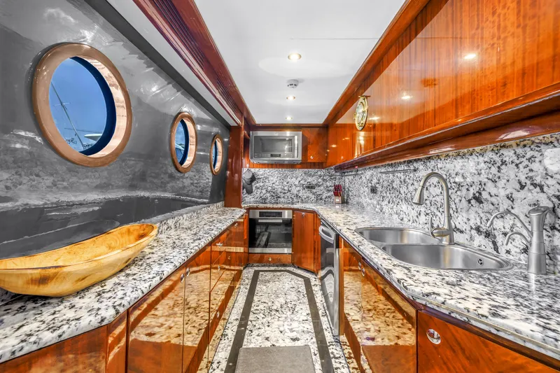 Star Saphire Yacht Photos Pics Luxurious yacht kitchen with granite countertops, wooden cabinetry, and porthole windows on a 2007 Bilgin 117.