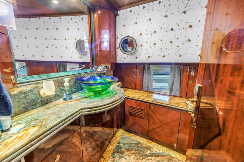 Star Saphire Yacht Photos Pics Luxurious Bilgin 117 yacht bathroom, featuring elegant wood finishes and a vibrant glass sink, 2007 model.