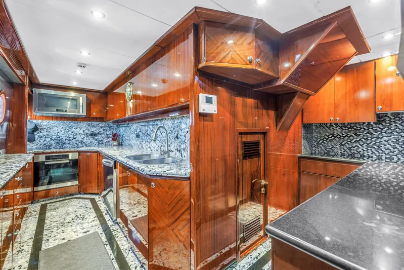 Star Saphire Yacht Photos Pics Luxurious Bilgin 117 yacht kitchen, 2007 model, featuring elegant wood cabinetry and granite countertops.