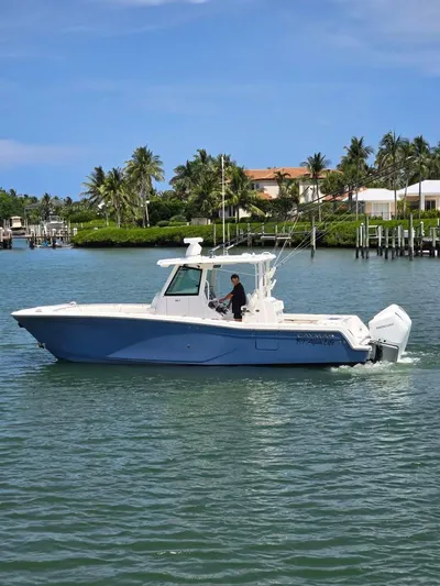  Yacht Photos Pics 2023 Caymas 30 CT boat cruising on a scenic waterway with palm trees.