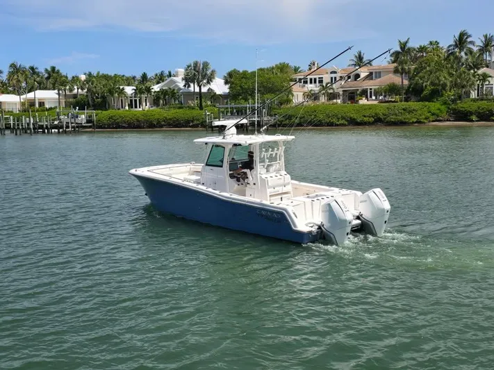  Yacht Photos Pics 2023 Caymas 30 CT boat cruising on a scenic waterway near luxury homes.