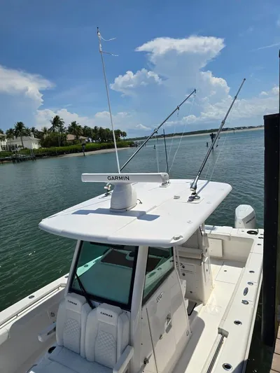  Yacht Photos Pics 2023 Caymas 30 CT boat docked, featuring Garmin equipment and fishing rods, under a clear sky.