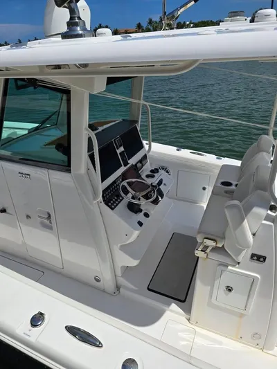  Yacht Photos Pics 2023 Caymas 30 CT boat cockpit with modern controls and seating, docked by the water.