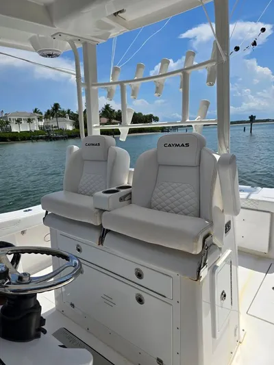 Yacht Photos Pics 2023 Caymas 30 CT boat interior with luxurious seating and rod holders, docked by the water.