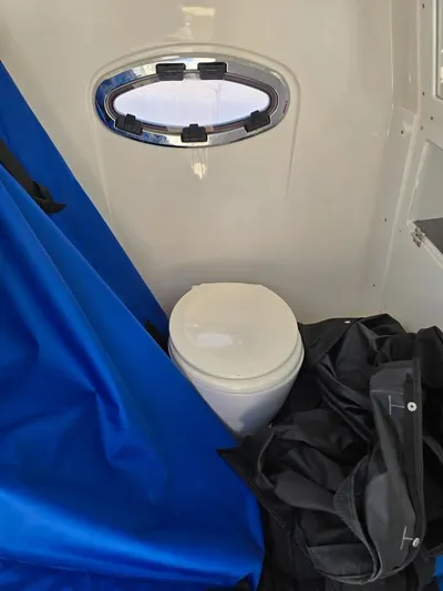  Yacht Photos Pics 2023 Caymas 30 CT boat interior with toilet and blue cover.