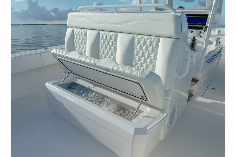  Yacht Photos Pics Manufacturer Provided Image: 2023 Invincible 33 Catamaran with luxurious seating and built-in cooler on a serene water backdrop.