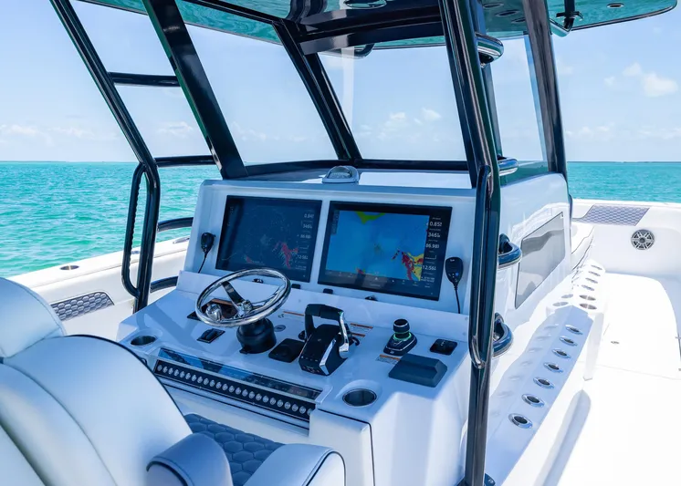  Yacht Photos Pics 2026 Invincible 38 Catamaran helm with dual screens, steering wheel, and ocean view.