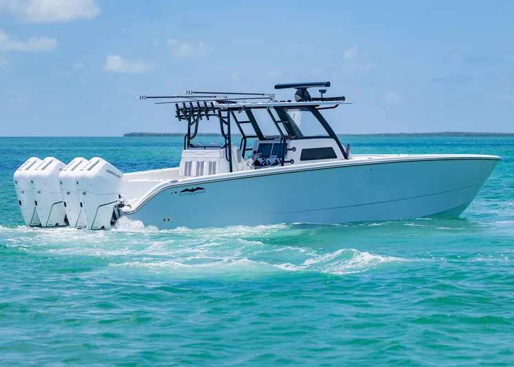  Yacht Photos Pics 2026 Invincible 38 Catamaran cruising on turquoise waters under a clear blue sky.