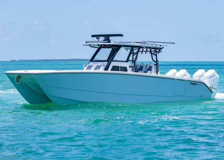  Yacht Photos Pics 2026 Invincible 38 Catamaran cruising on clear blue ocean waters.