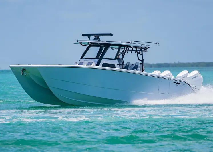  Yacht Photos Pics 2026 Invincible 38 Catamaran cruising on turquoise waters.