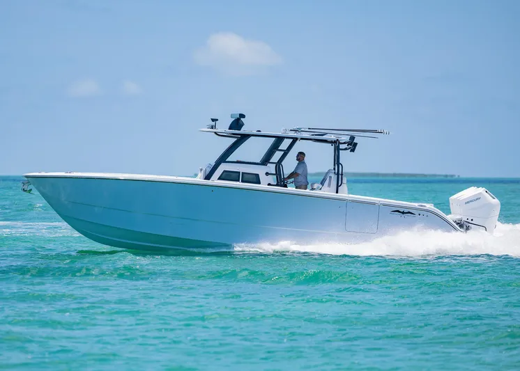  Yacht Photos Pics 2026 Invincible 38 Catamaran cruising on clear turquoise waters under a sunny sky.