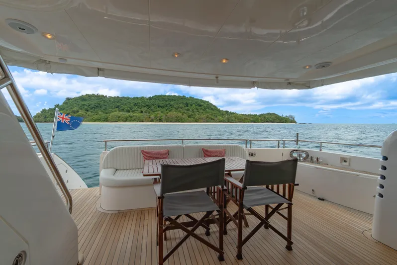 Blue Rose Yacht Photos Pics Luxury yacht deck with seating, ocean view, and island backdrop; Princess 23M, 2006 model.