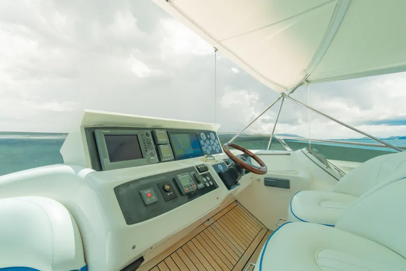 Blue Rose Yacht Photos Pics Luxury yacht helm with modern controls, Princess 23M, 2006 model, featuring wooden steering wheel.