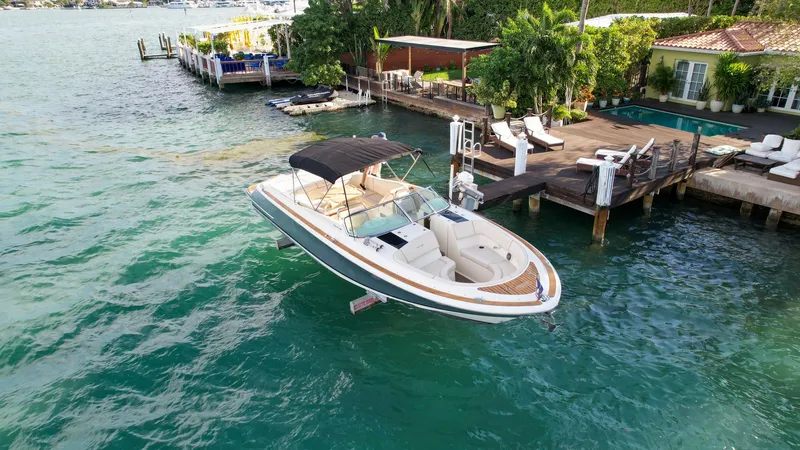 Minsky's Folly II Yacht Photos Pics 2014 Chris-Craft Launch 32 boat docked by a luxurious waterfront property.