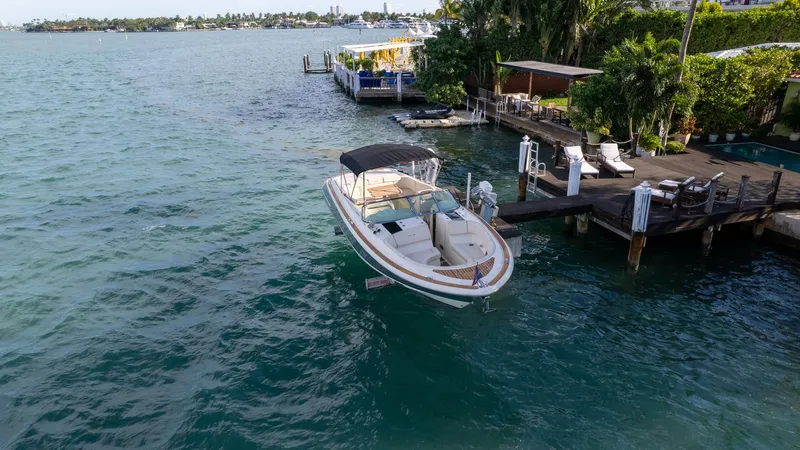 Minsky's Folly II Yacht Photos Pics 2014 Chris-Craft Launch 32 boat docked by a scenic waterfront.