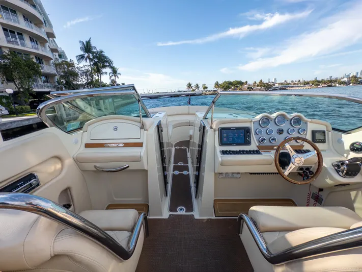 Minsky's Folly II Yacht Photos Pics 2014 Chris-Craft Launch 32 boat interior with dashboard and steering wheel, docked by waterfront.