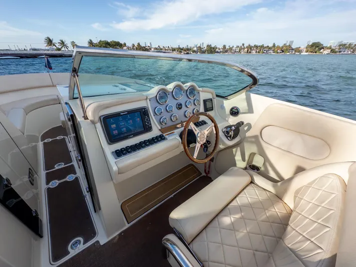 Minsky's Folly II Yacht Photos Pics 2014 Chris-Craft Launch 32 boat interior with steering wheel and dashboard, on a sunny day.
