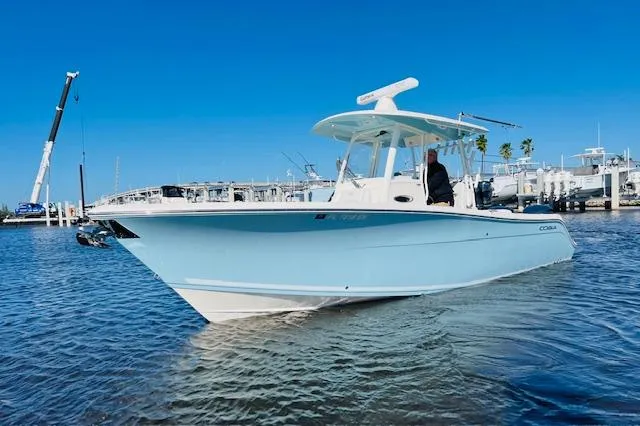 Yacht Photos Pics 2021 Cobia 301 Center Console boat on water, clear blue sky background.