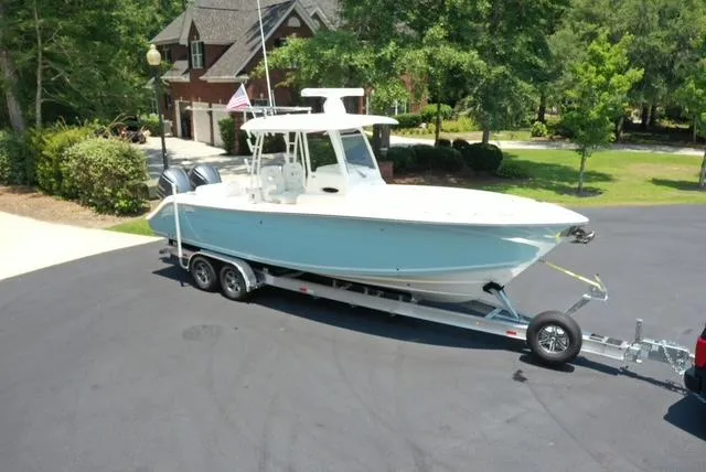  Yacht Photos Pics 2021 Cobia 301 Center Console boat on trailer in residential driveway.