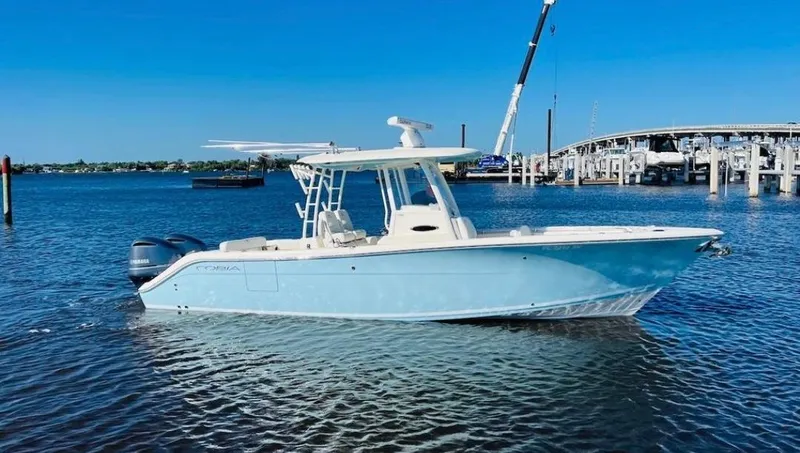  Yacht Photos Pics 2021 Cobia 301 Center Console boat on water, clear sky, marina background.